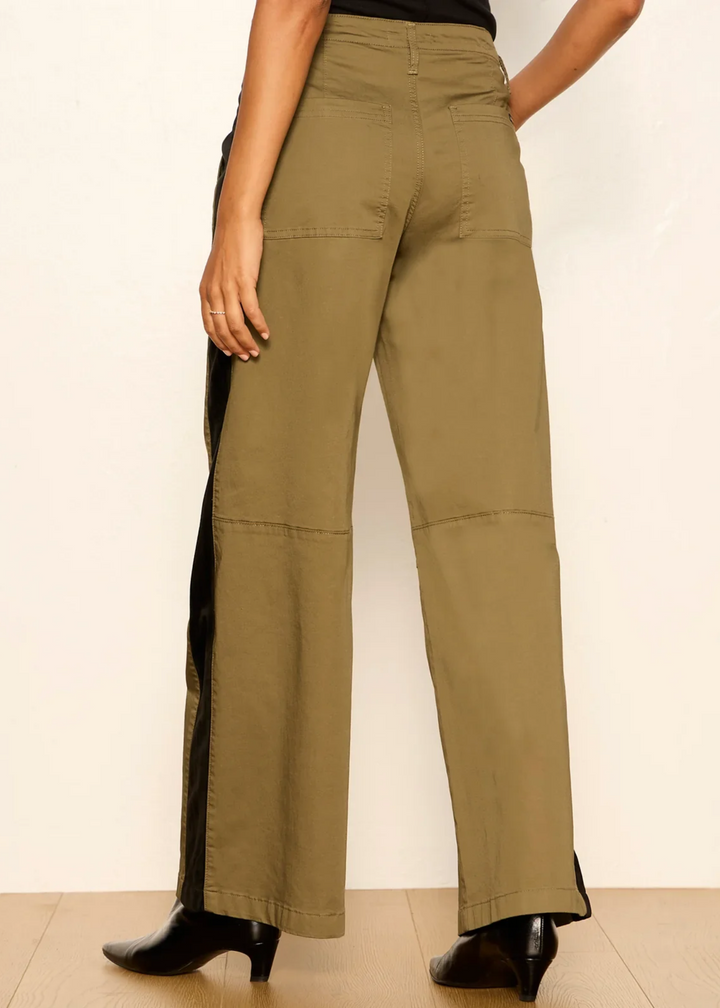 Woman wearing vintage olive pants with black boots.