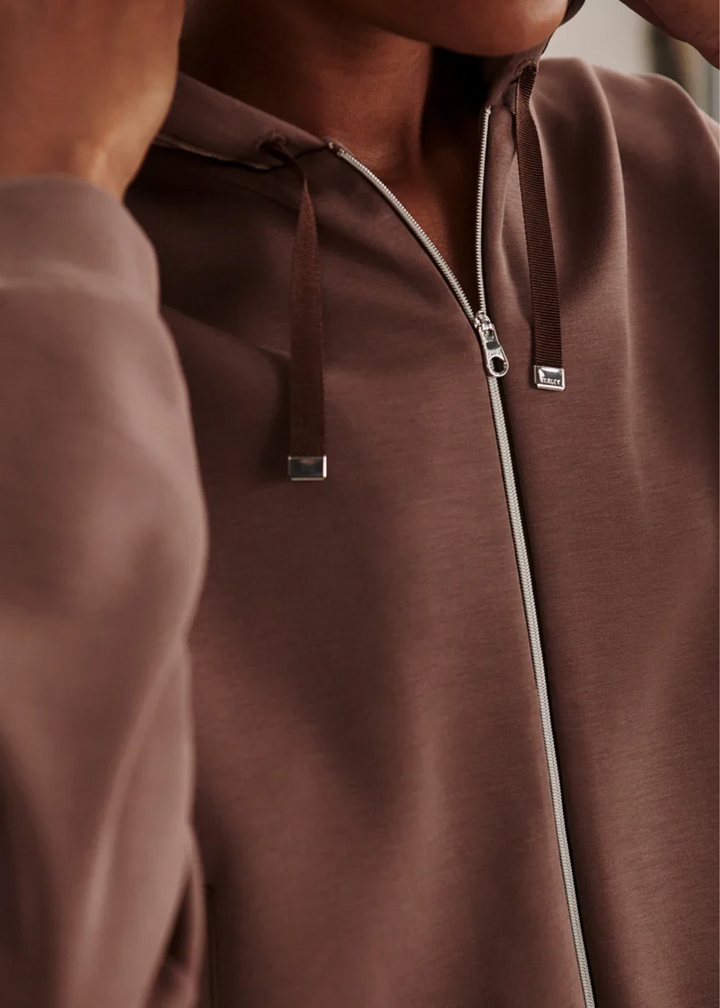 Close up of a woman wearing a coffee colored sweat set.