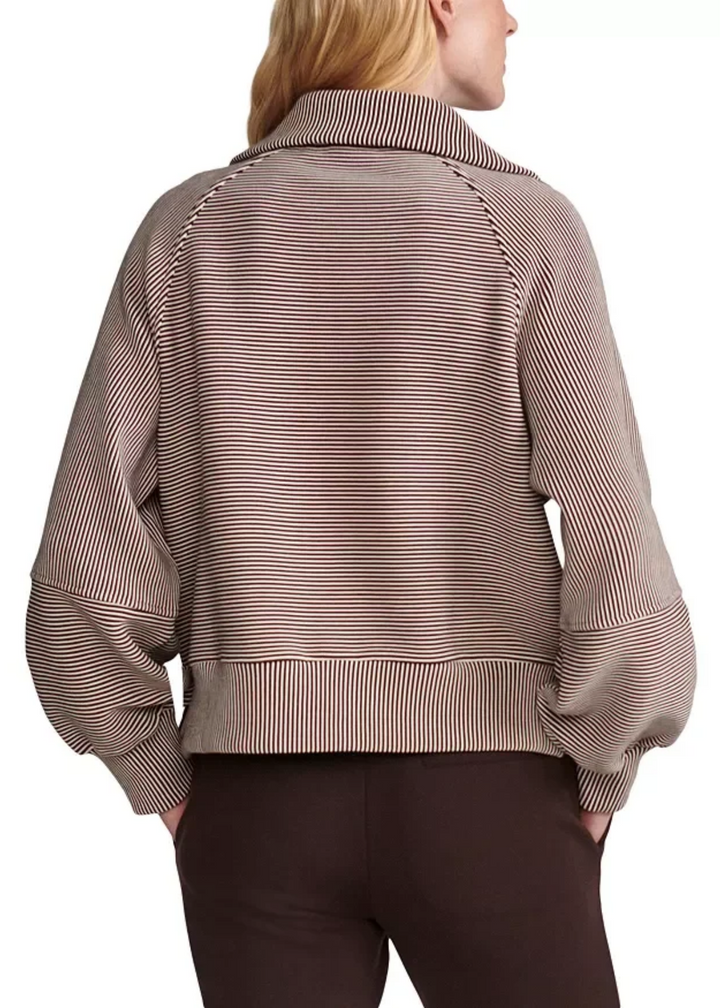 Woman turned around in a striped coffee bean/birch half zip. 
