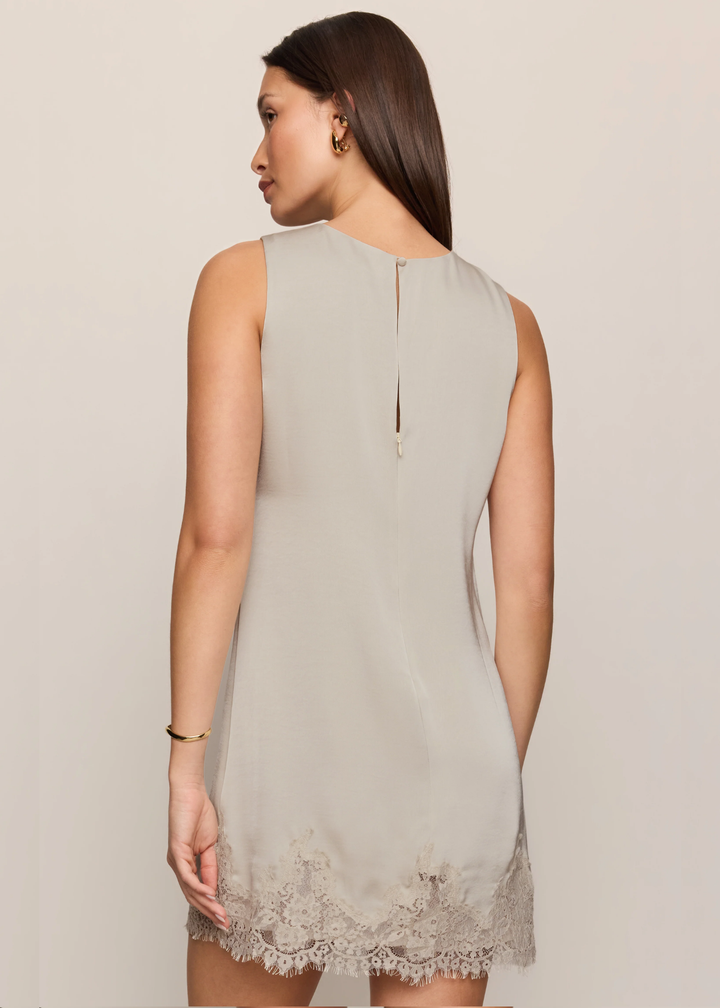 Women wearing lace mini dress that is satin, and she is turned around. 