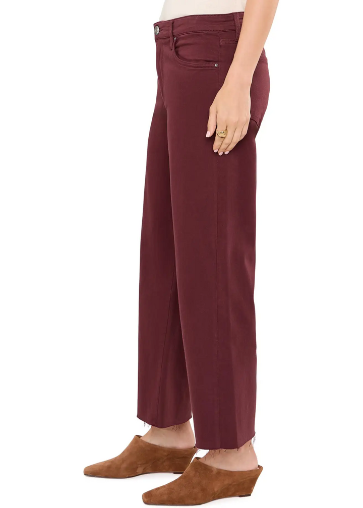 A person wearing high-waisted, wide-leg cropped pants in a deep burgundy color, paired with brown suede mule shoes, shown from the waist down against a plain white background.