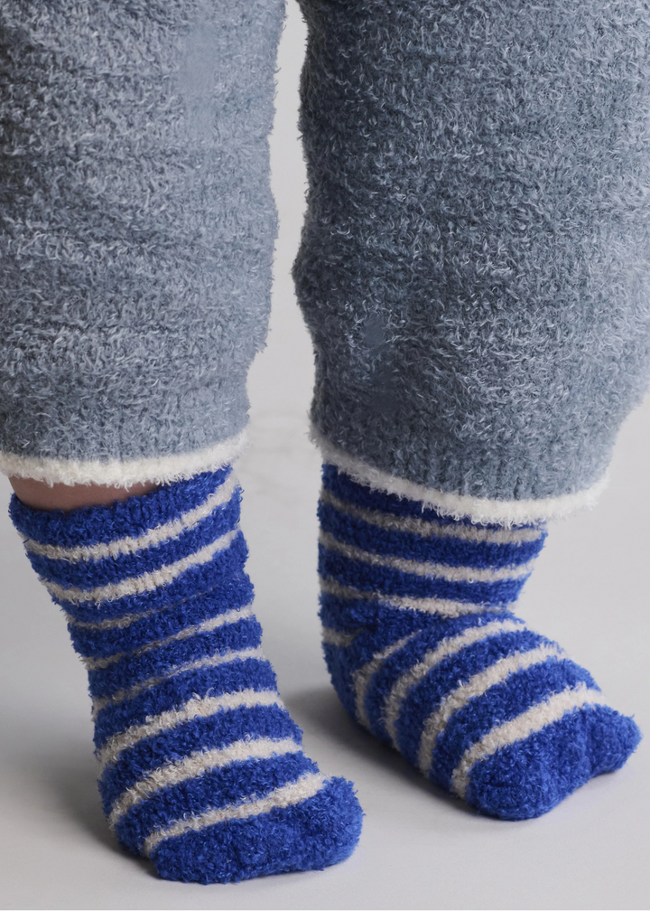Baby wearing cobalt blue socks with white stripes