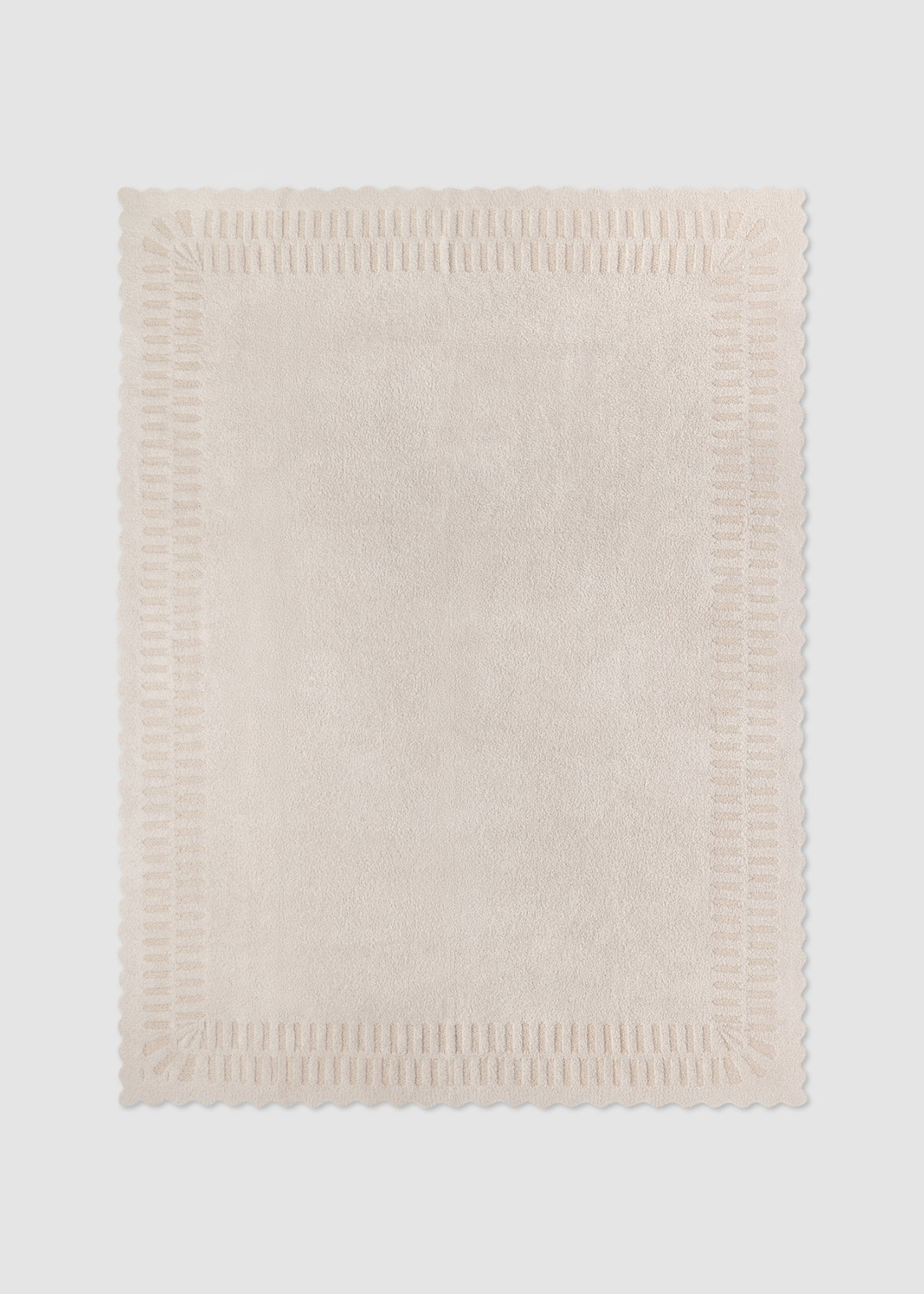 Cream blanket laying on a grey background