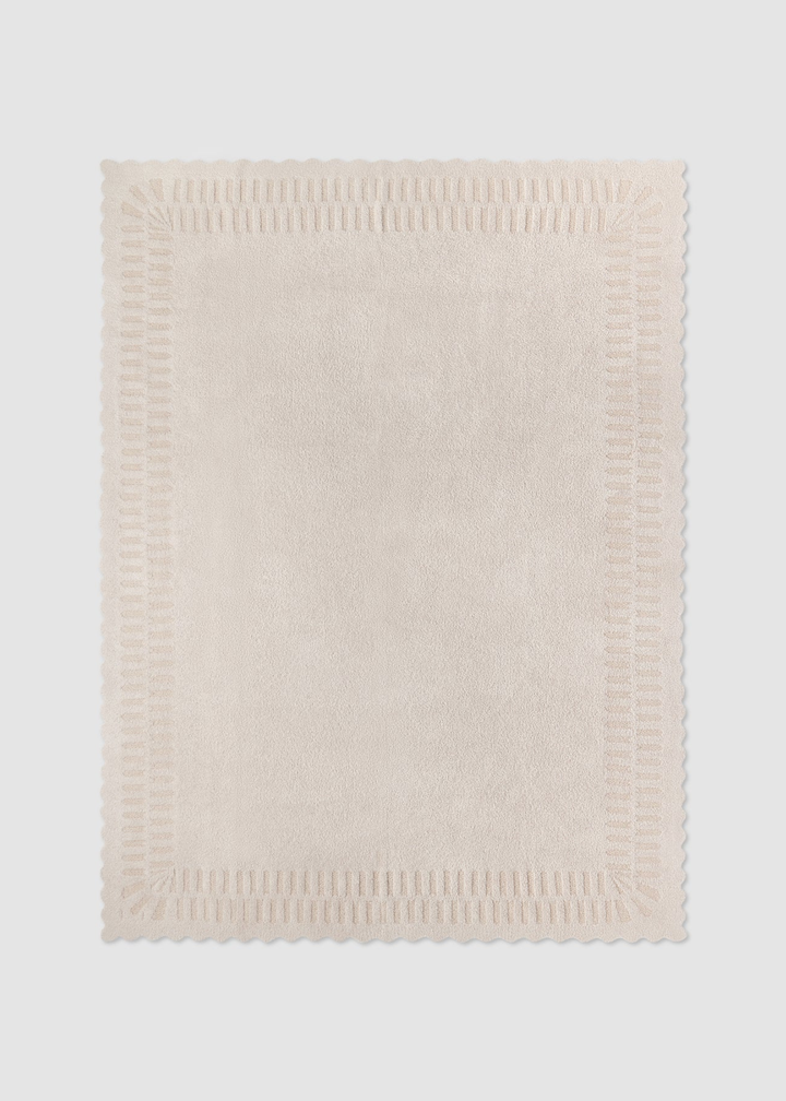 Cream blanket laying on a grey background