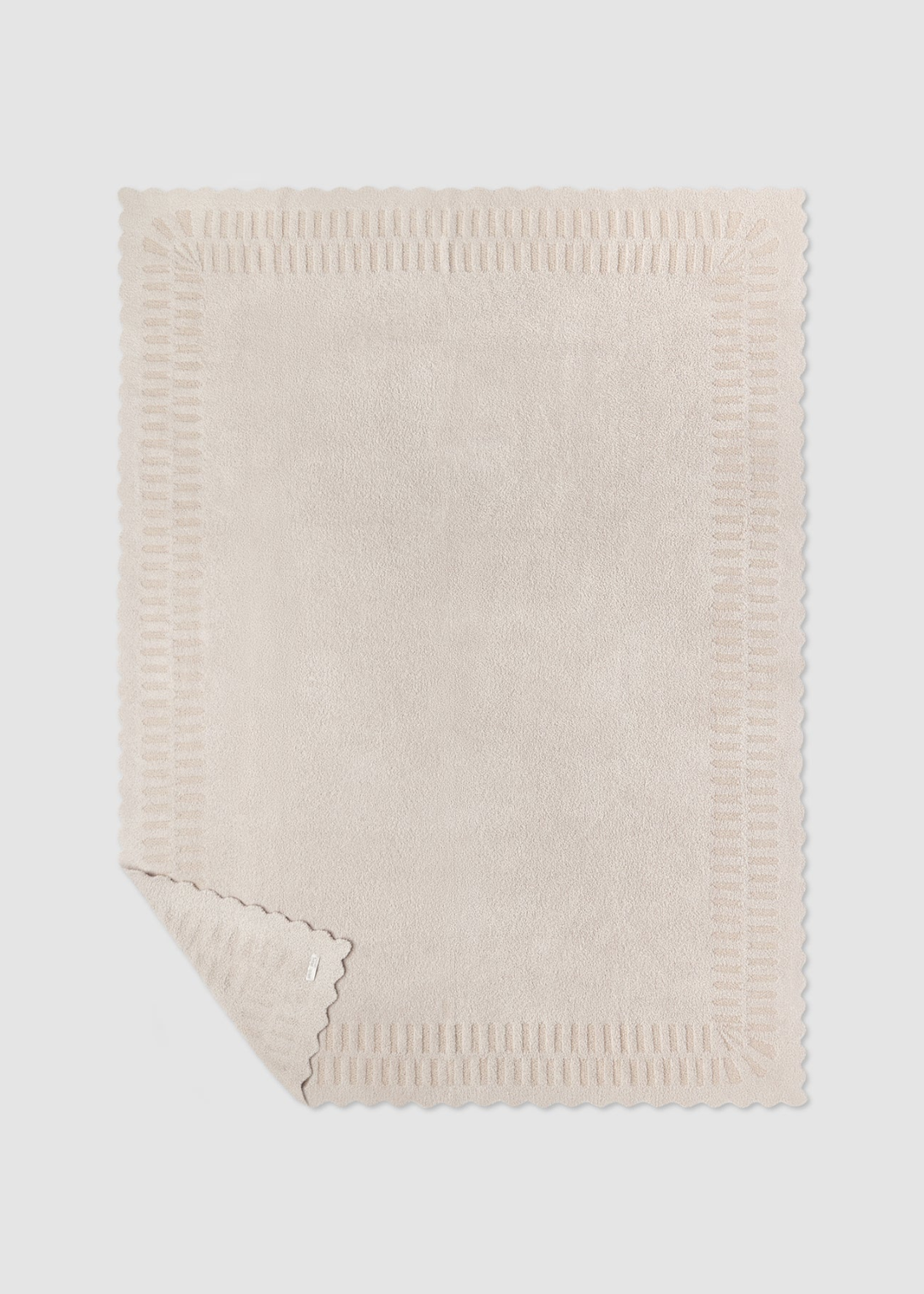 Cream blanket laying on a grey background