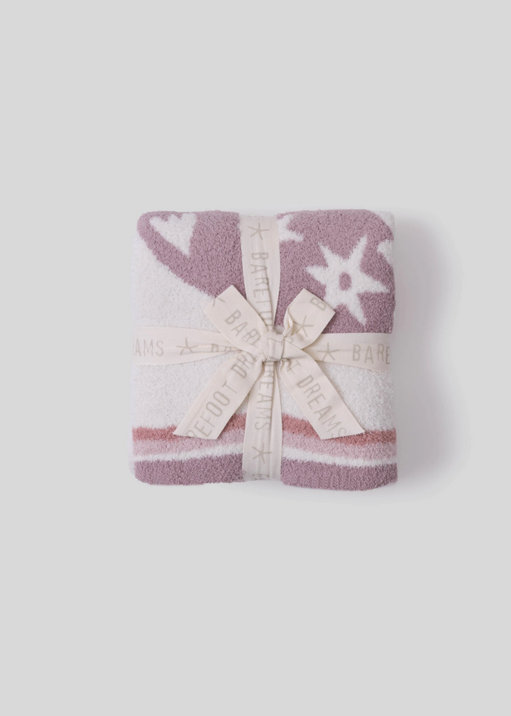 Pink blanket folded on a white background with a bow