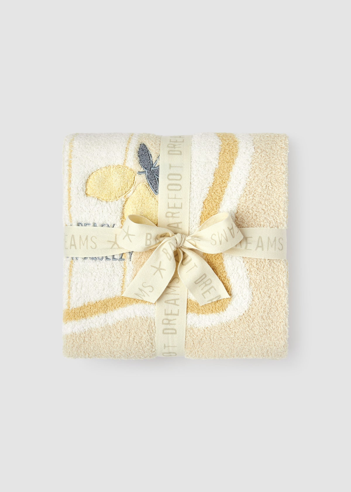 Yellow blanket with a lemon pattern folded and tied with a yellow bow