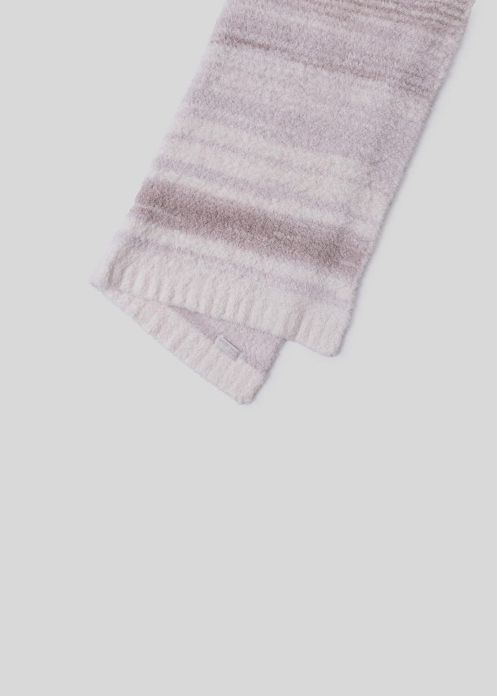 Pink and cream striped blanket folded in half laying on a white background