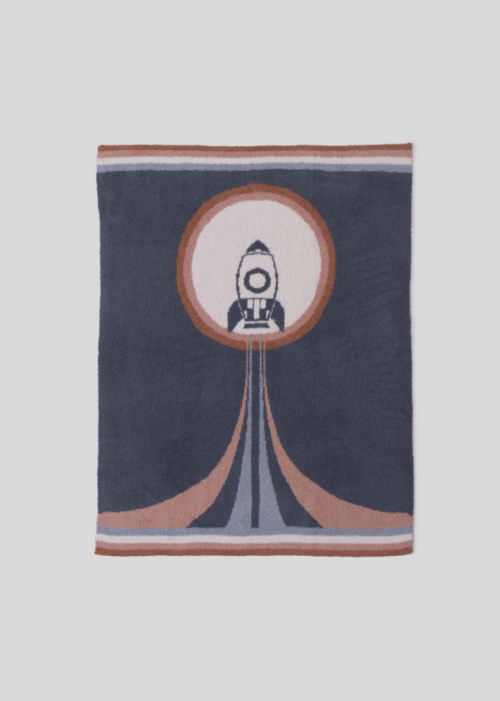 Dark blue blanket with orange, white, and light blue accents with a spaceship graphic laying on a white background