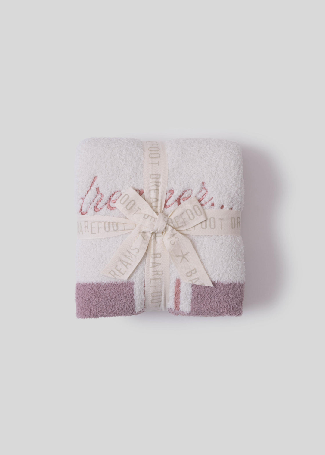 Pink blanket folded and tied with a bow on a white background