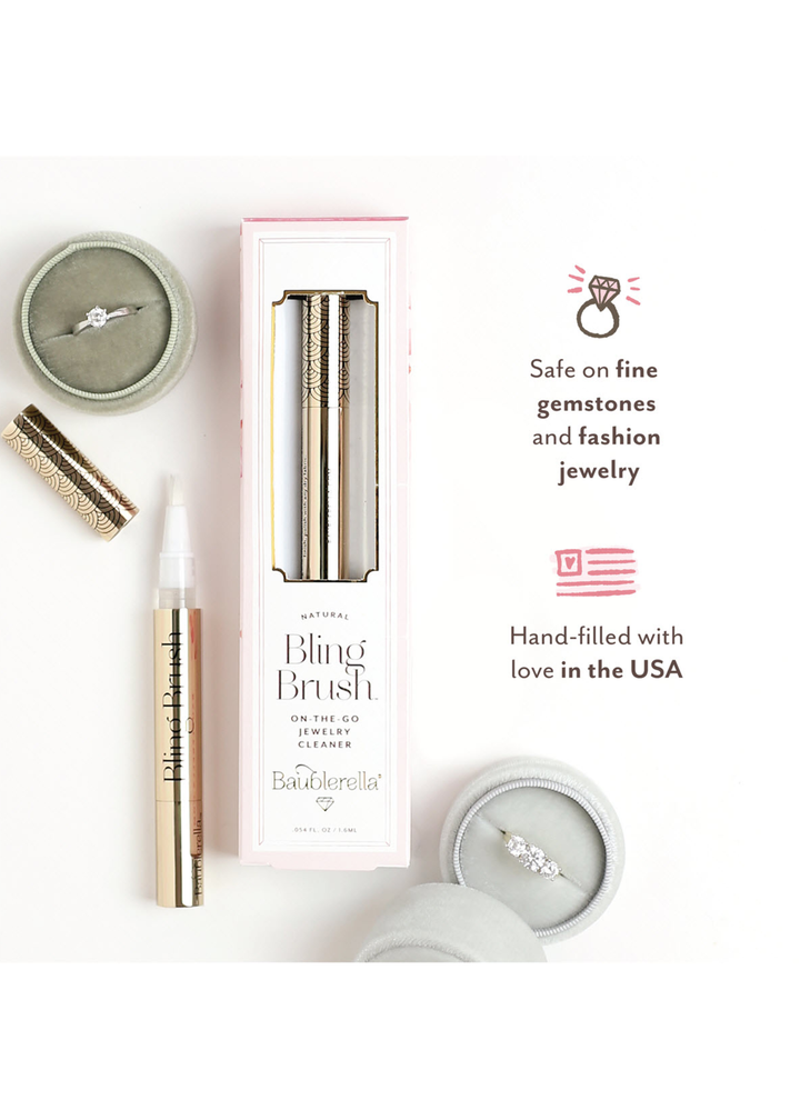 Flat lay with rings, jewelry cleaning brush, packaging, and wording