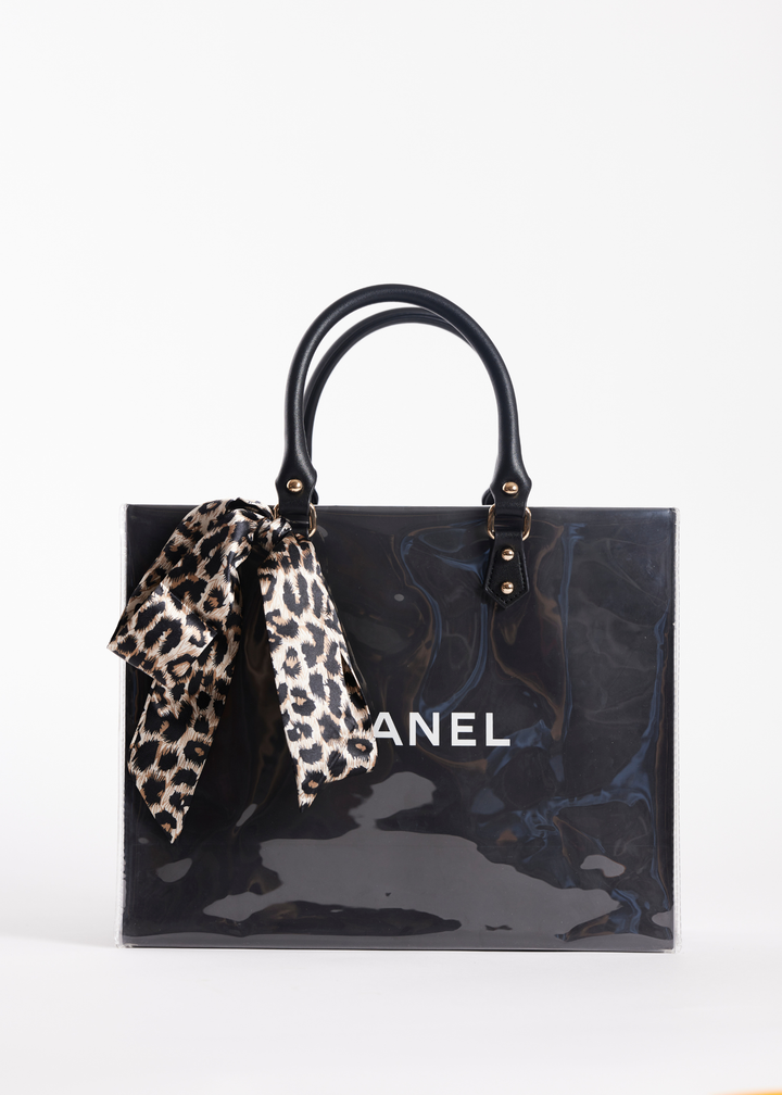 Clear coated black Chanel shopping bag with a leopard print scarf handle