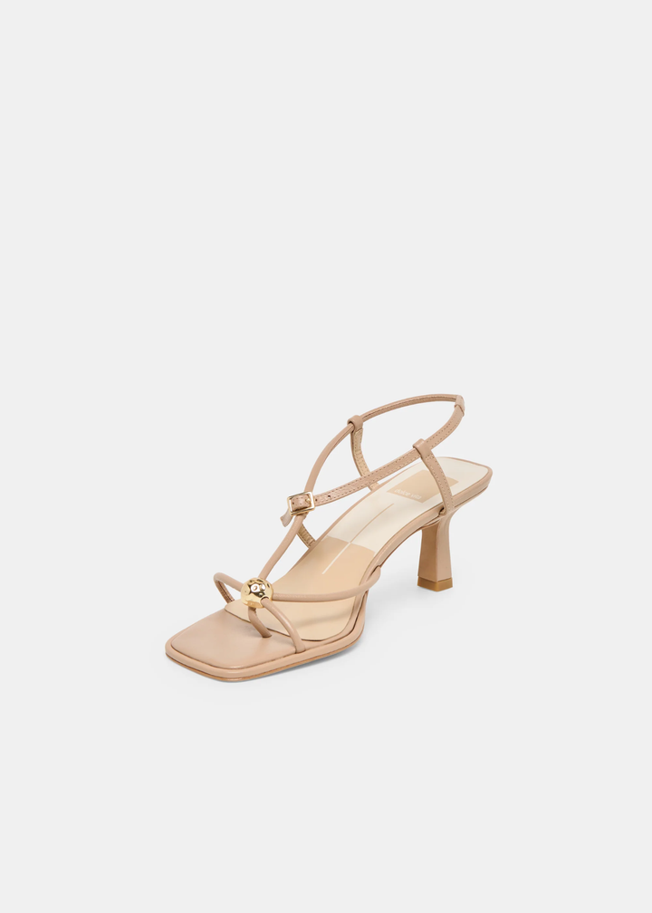 Front view of tan strappy heels with a gold button against a white background