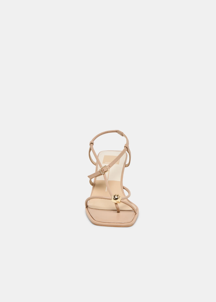 Front view of tan strappy heels with a gold button against a white background