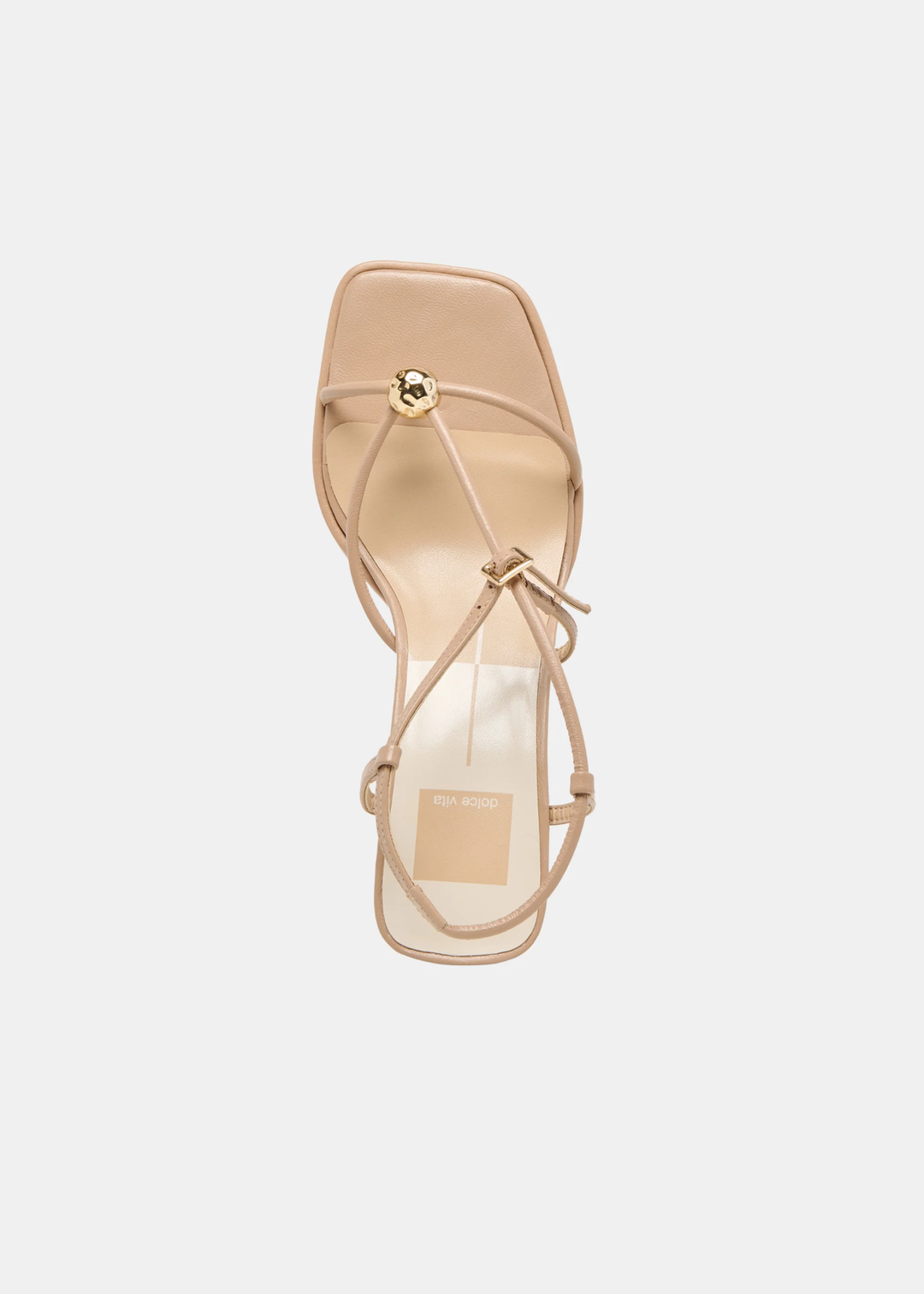 Top view of tan strappy heels with a gold button against a white background
