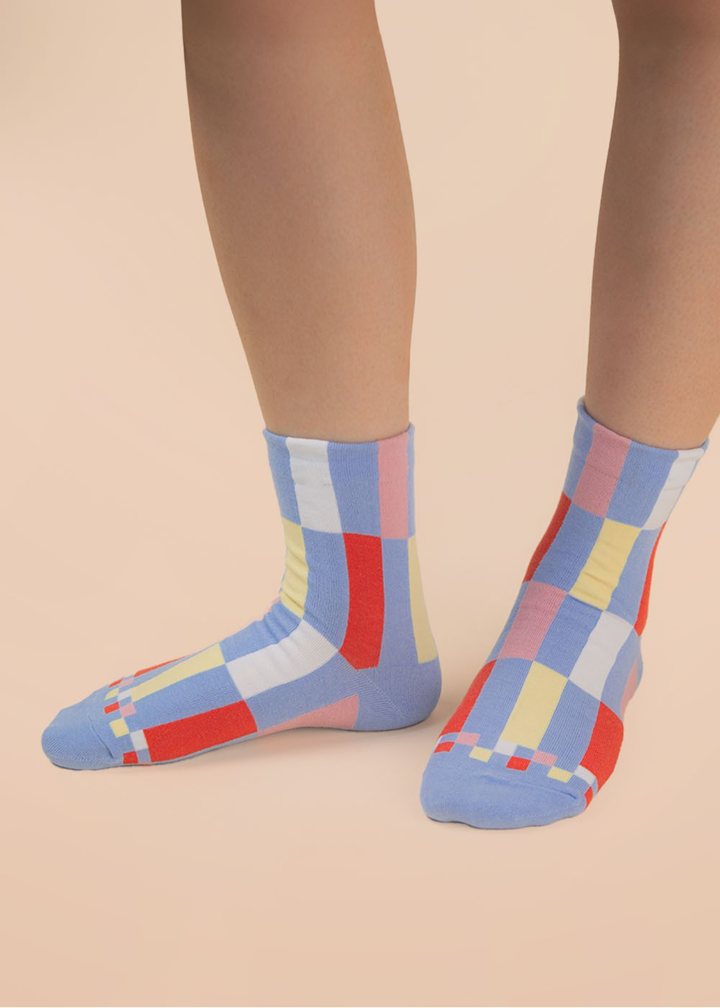 Person wearing blue and multicolor colorblock crew socks
