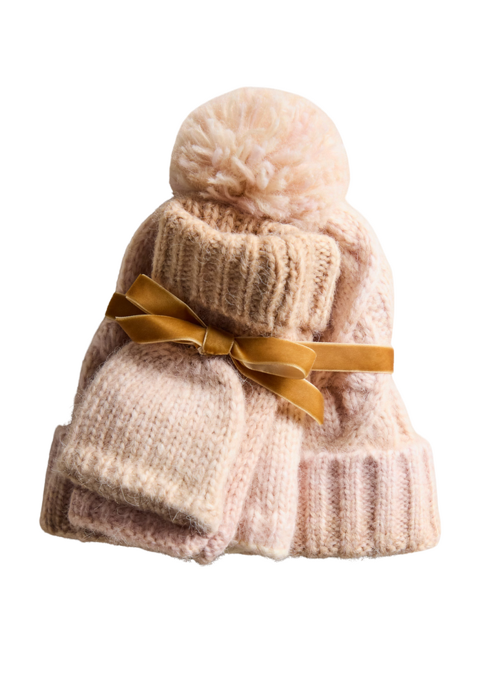 Ivory beanie and gloves tied together with a gold ribbon on a white background