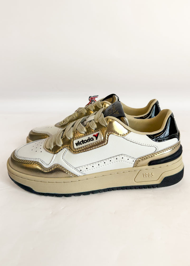 White and beige sneakers with a visible brand logo on a light gray background