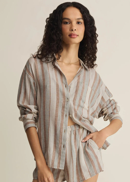 Woman wearing a striped shirt and shorts set on a beige background
