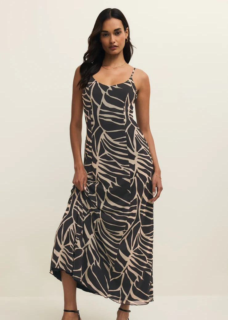 Woman wearing a black and beige patterned dress on a white background