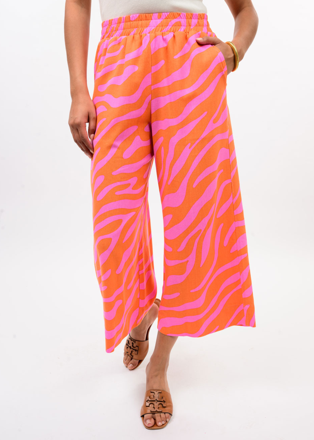 Woman wearing pink and orange zebra print pants with a white top