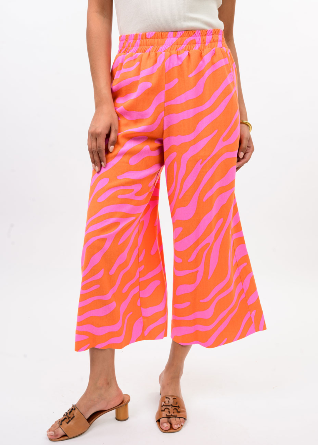 Woman wearing pink and orange zebra print pants with a white top