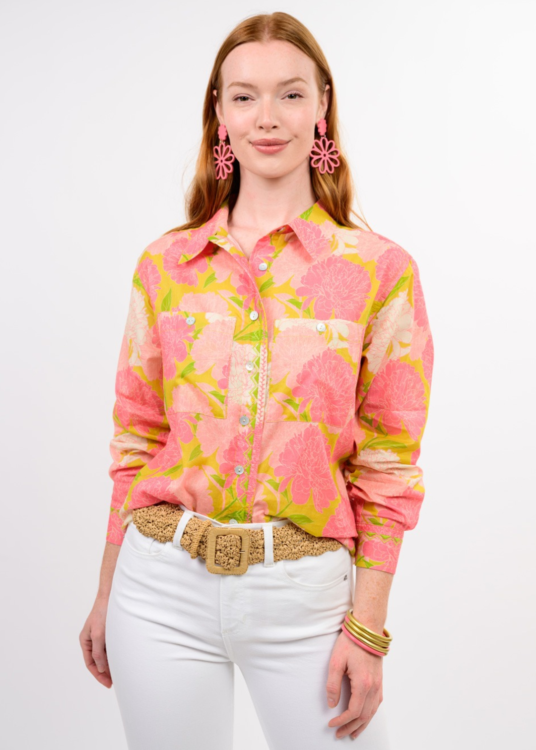 Woman wearing a pink floral button down with white jeans
