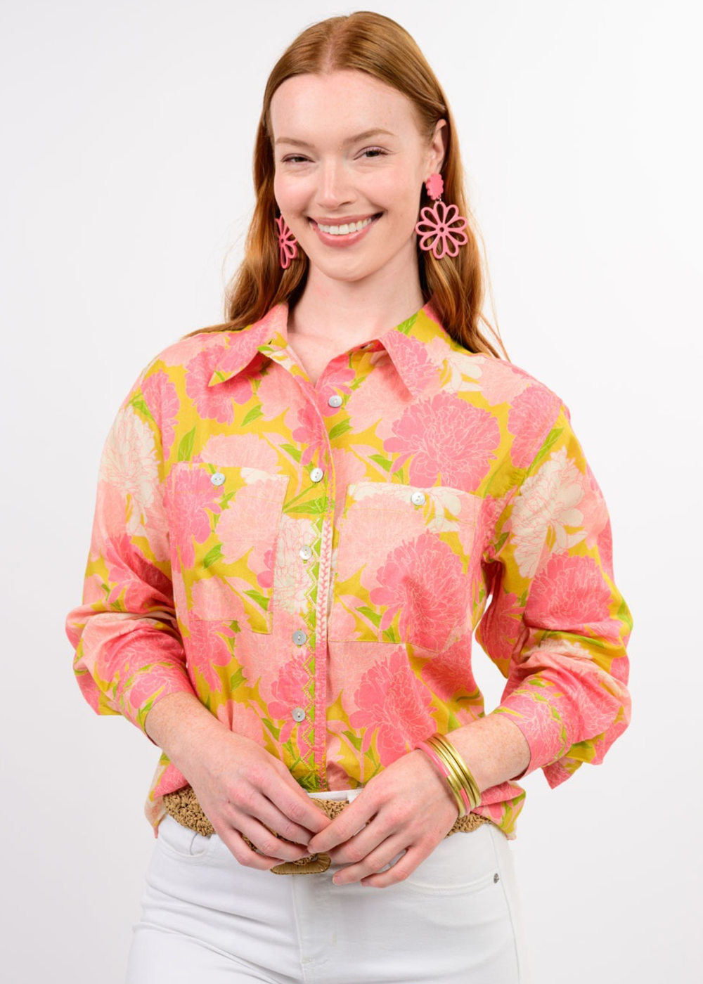 Woman wearing a pink floral button down with white jeans