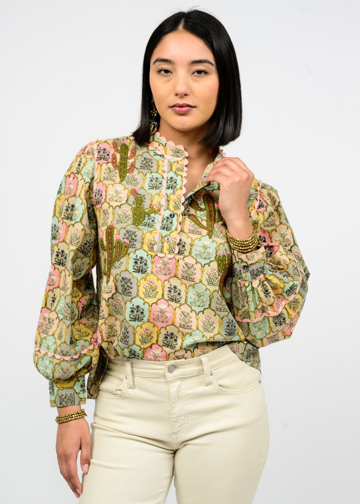 Woman wearing a patterned, multicolor long sleeve top