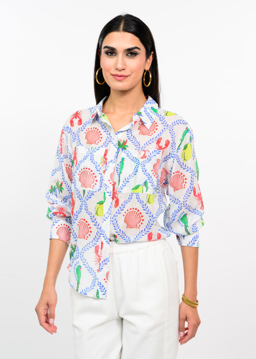 Woman wearing a white button down with a multicolor pattern with white jeans