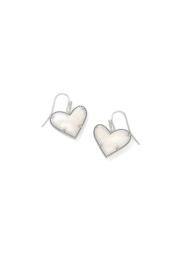 Silver framed heart shaped earrings with an ivory stone on a white background