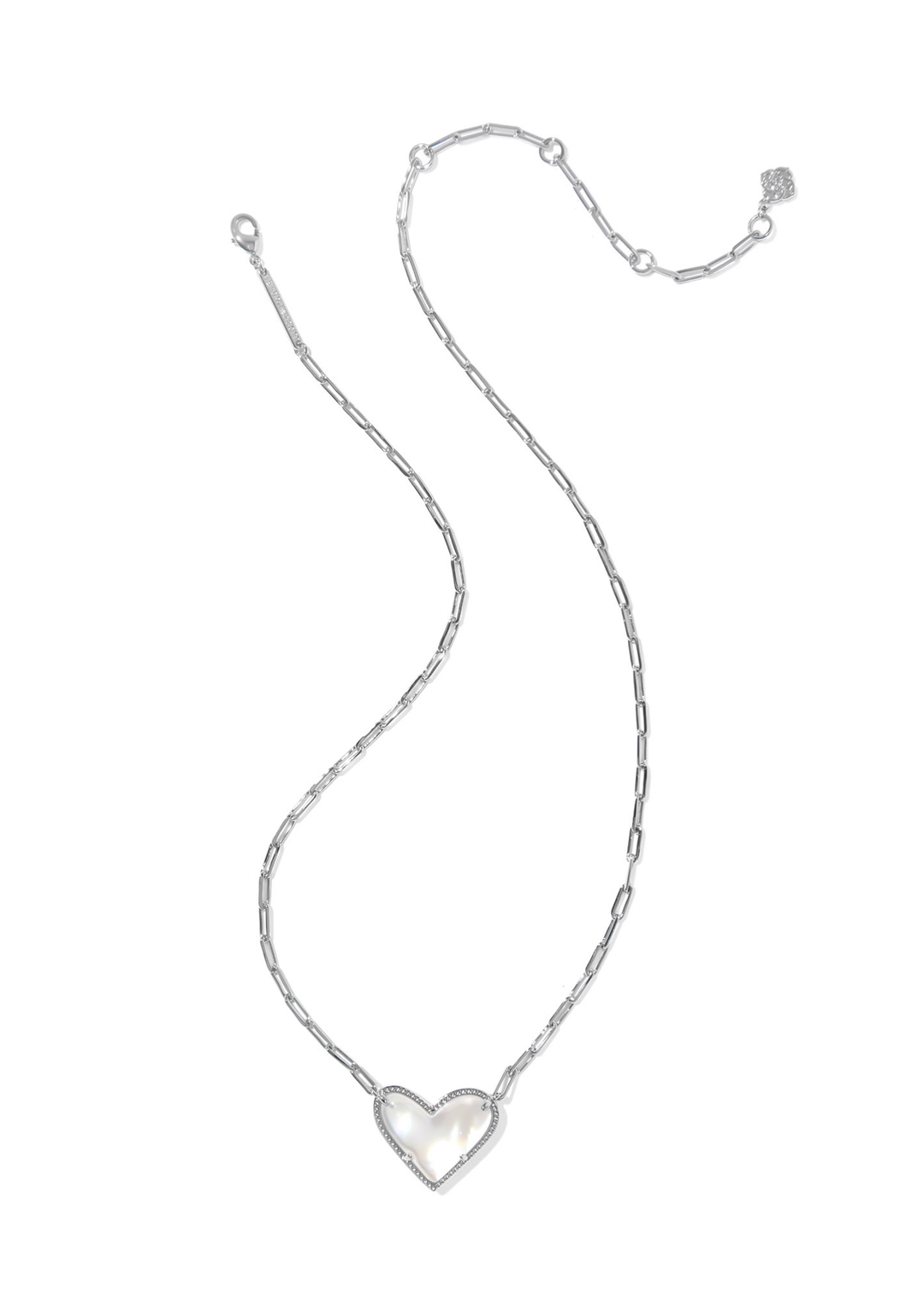 A silver necklace with a silver framed heart shaped pendant with an ivory stone against a white background