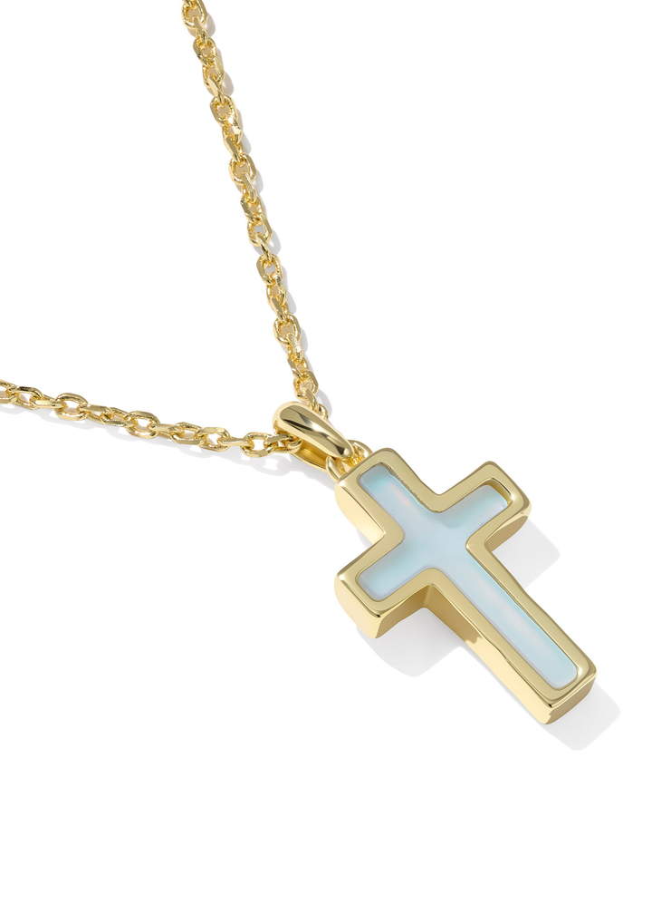 Close up of a gold framed cross pendant with a light blue stone on a gold chain necklace