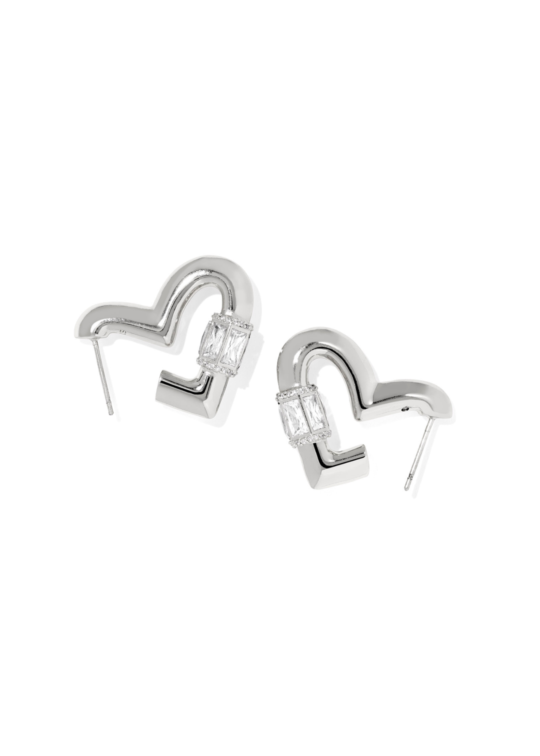 A pair of rhodium heart shaped hoop earrings with CZ details laying on a white background