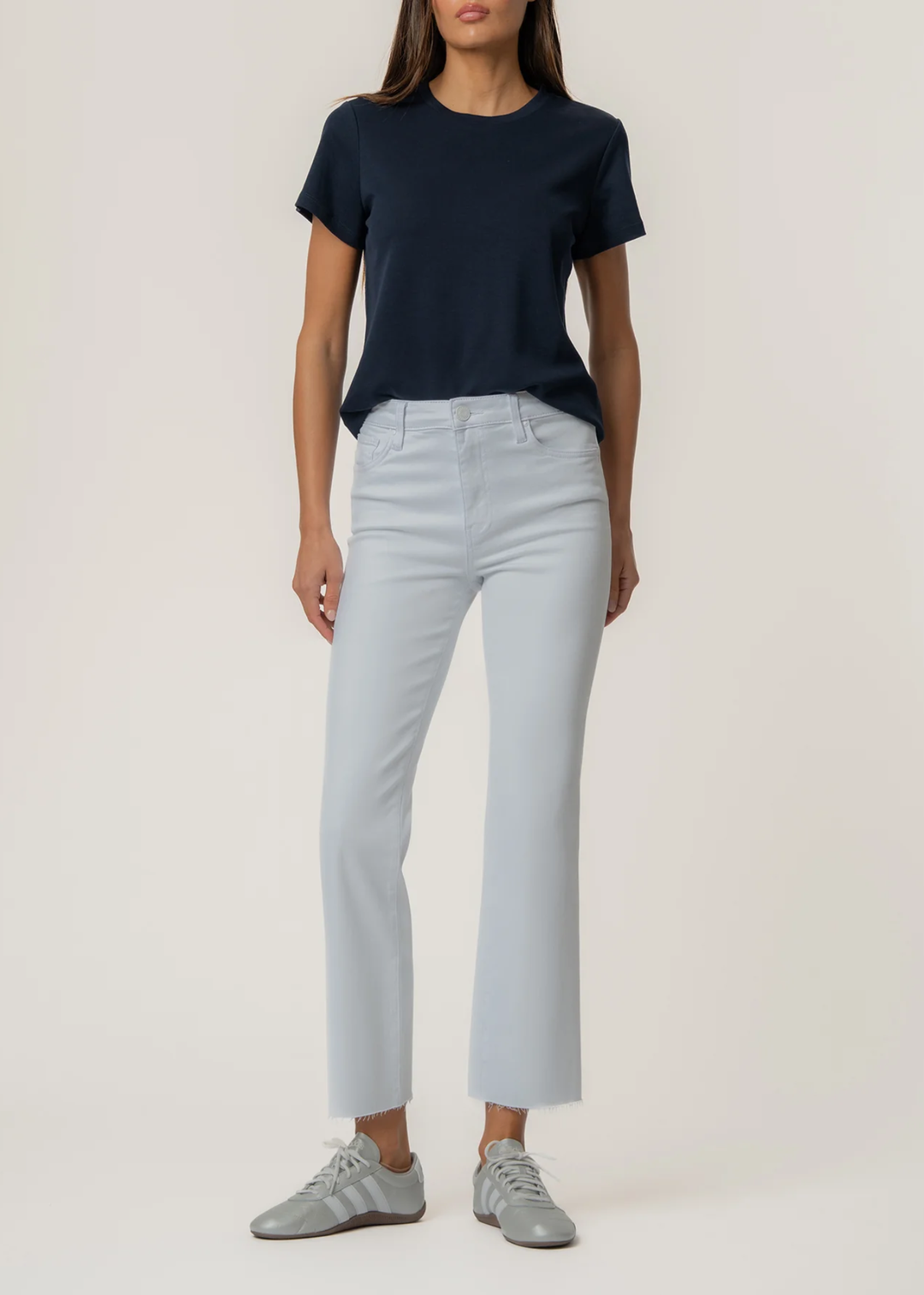 Woman wearing a white flare jean with a t-shirt and sneakers