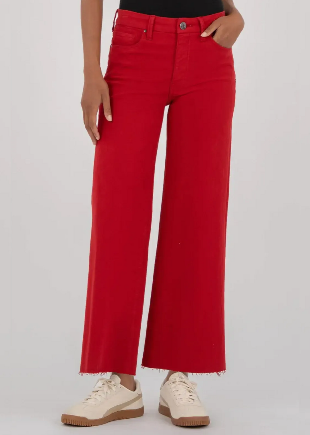 Woman wearing red wide leg jeans in front of a grey background