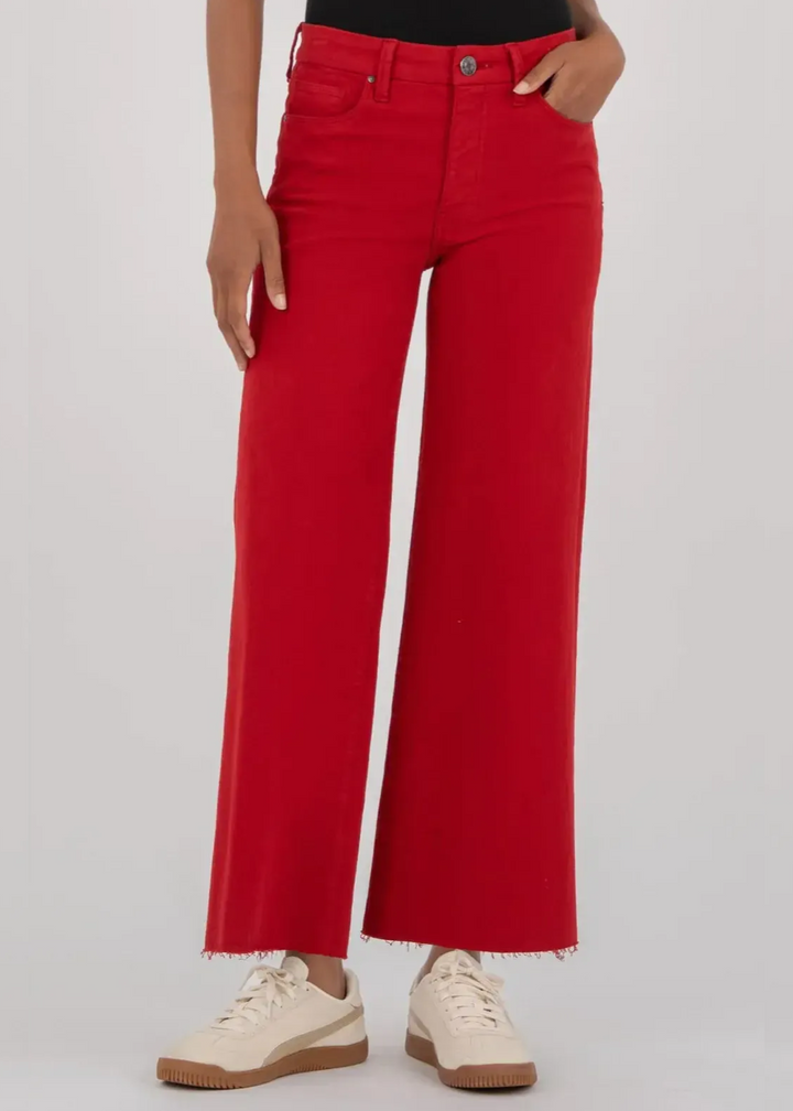 Woman wearing red wide leg jeans in front of a grey background