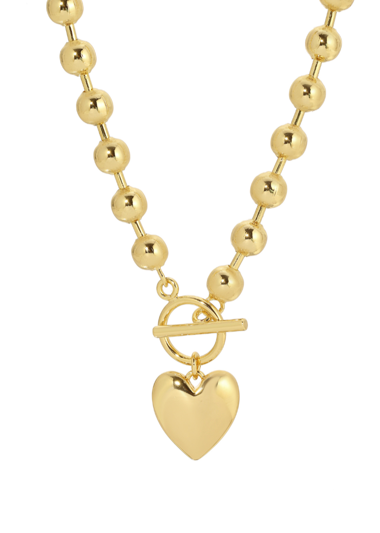 A stunning gold necklace featuring polished beads, a toggle clasp, and a heart pendant from Leeada's Le Bebe collection.