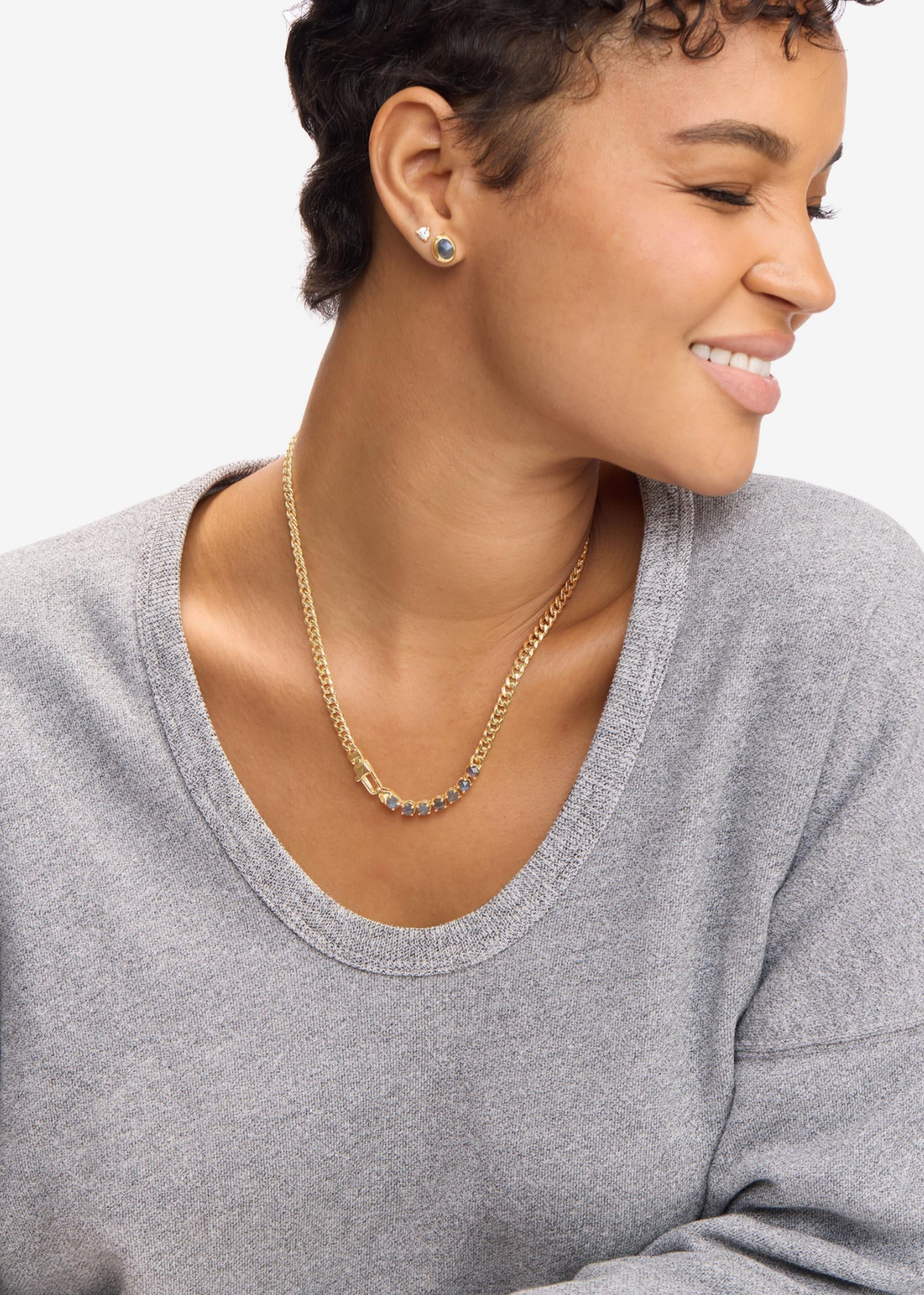 Woman wearing a gold chain necklace with seven labradorite stones