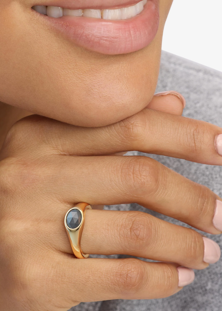 Woman wearing a gold signet ring with a labradorite stone