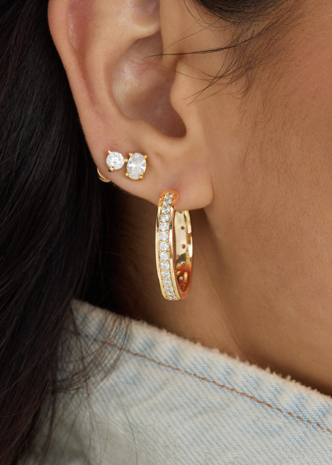 Woman wearing diamond studs earrings and a gold hoop with CZ studding