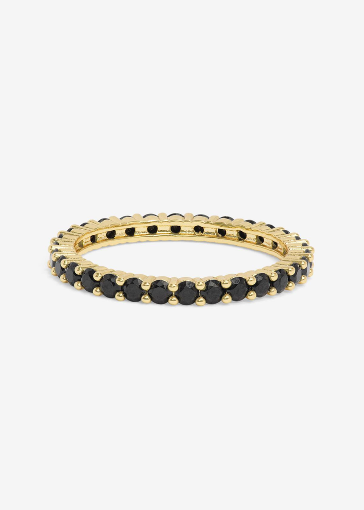 Gold framed ring with black simulated diamonds on a white background