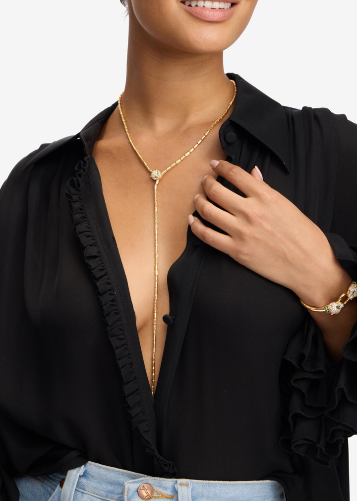 Woman wearing a gold lariat necklace with a jaguar head clasp