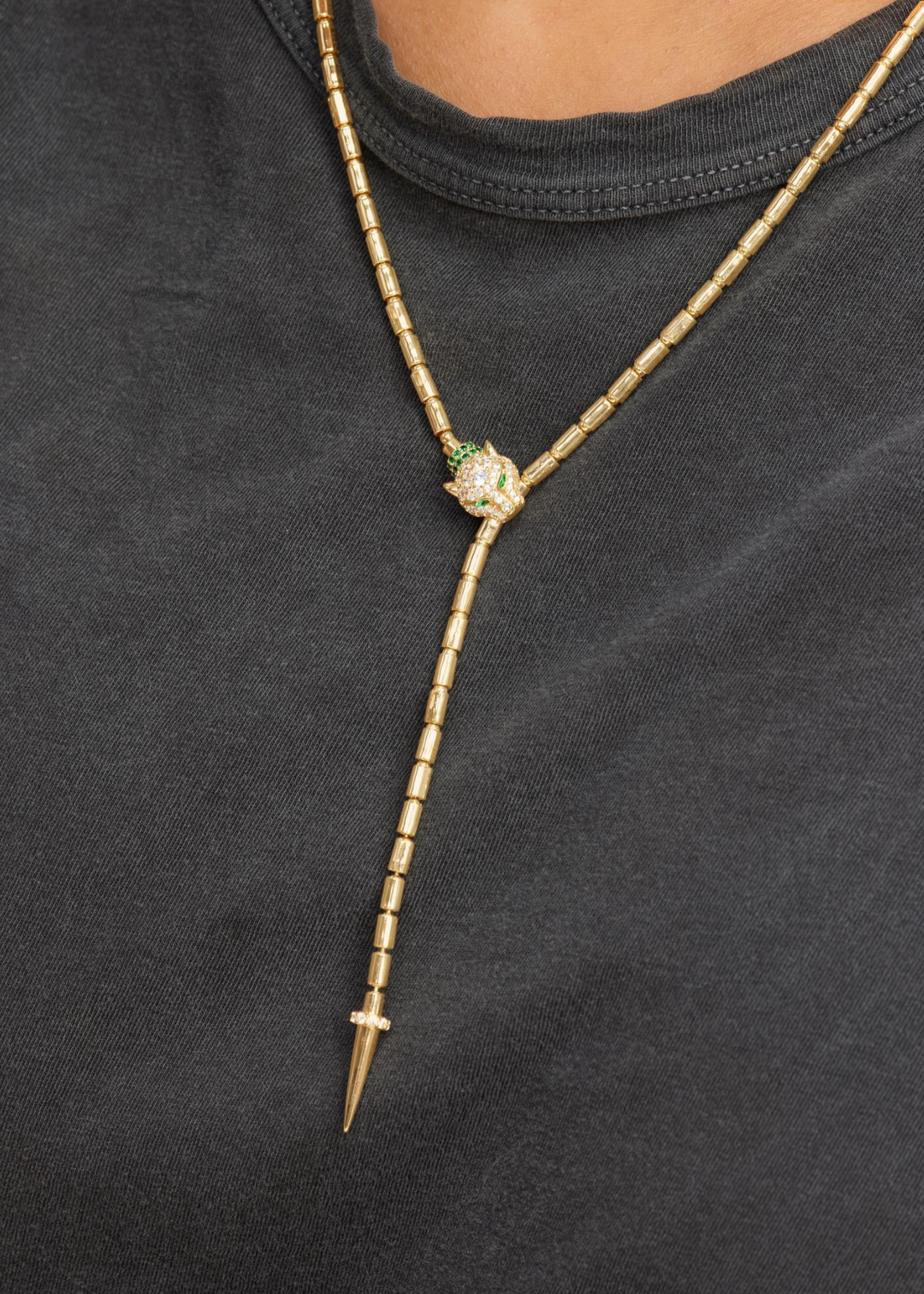 Woman wearing a gold lariat necklace with a jaguar head clasp