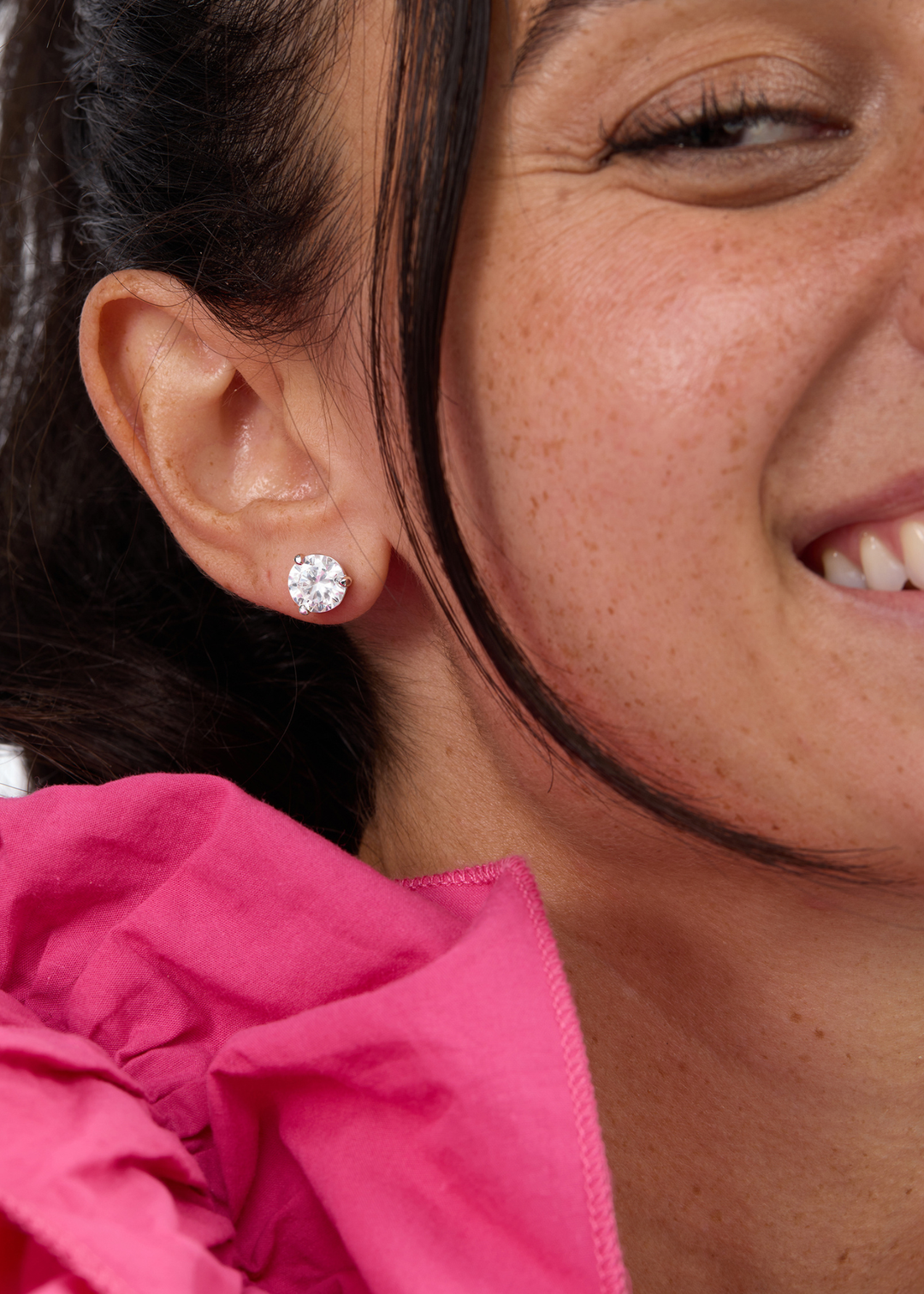 Woman wearing silver framed simulated diamond stud earrings