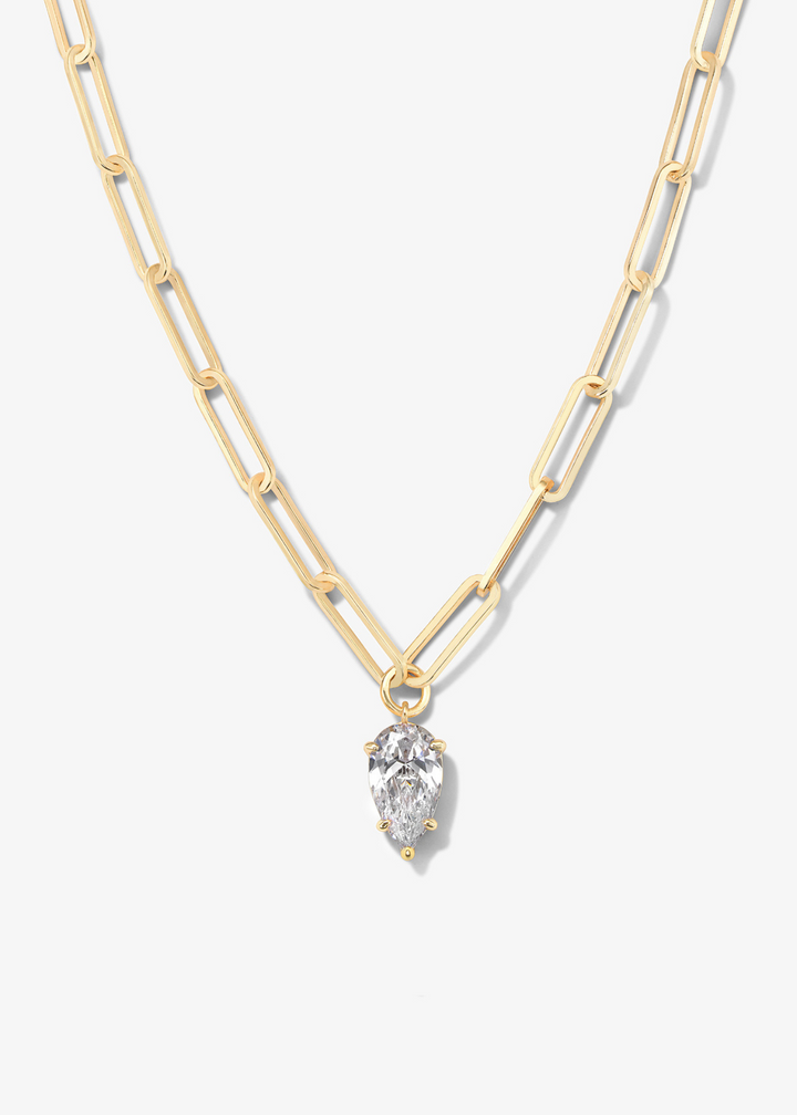 Gold chain necklace with a teardrop diamond pendant on a white background