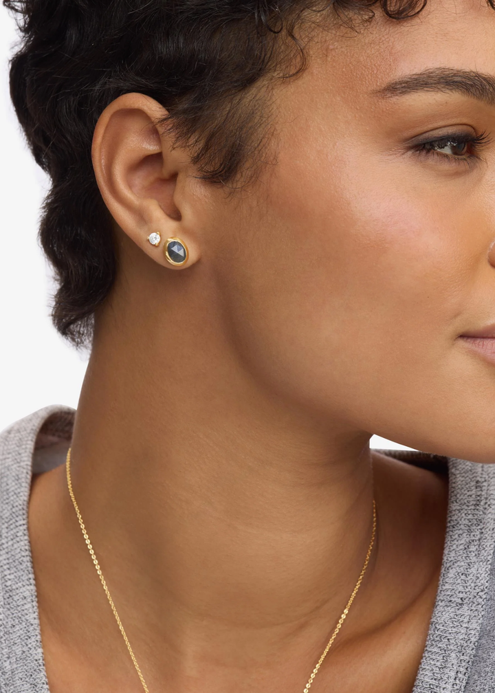 Woman wearing gold framed labradorite stud earrings