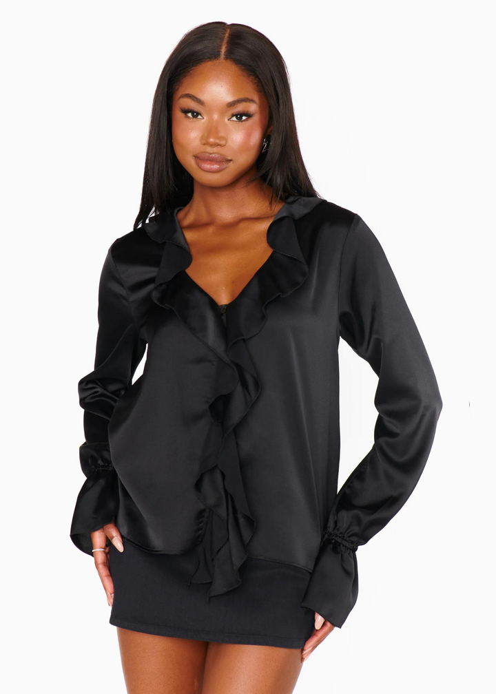 Black v-neck blouse with ruffle details on front and cinched cuff sleeves