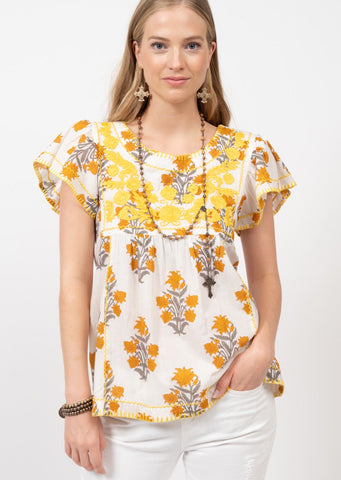 white, orange, and taupe floral print blouse with yellow embroidery and short ruffle sleeves