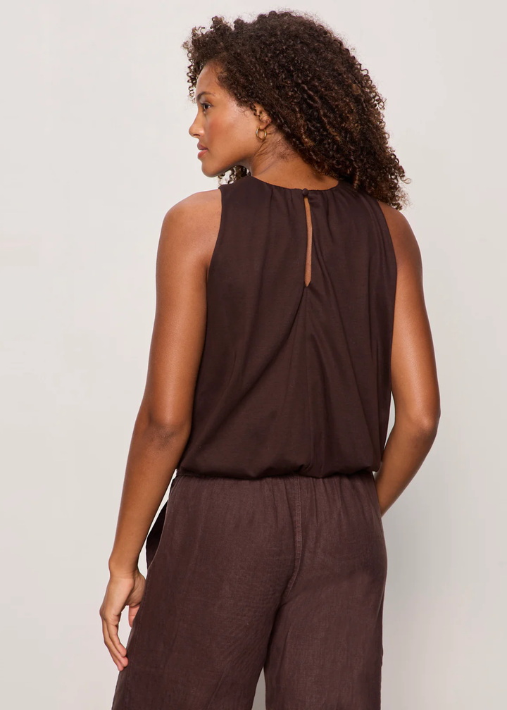 Woman turned around wearing a brown tank top with matching pants